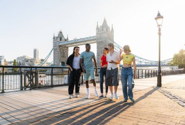 Londra 'da, Tower Bridge bölgesinde buluşup eğlenen çok ırklı genç arkadaş grubu gençlik yaşam tarzı, seyahat ve turizm konseptleri