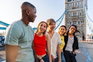 Londra 'da, Tower Bridge bölgesinde buluşup eğlenen çok ırklı genç arkadaş grubu gençlik yaşam tarzı, seyahat ve turizm konseptleri