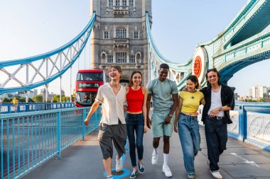 Londra 'da, Tower Bridge bölgesinde buluşup eğlenen çok ırklı genç arkadaş grubu gençlik yaşam tarzı, seyahat ve turizm konseptleri