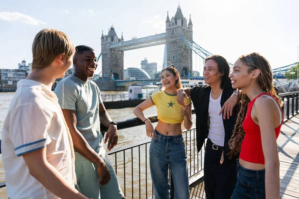 ロンドン市で結ばれる幸せな若い友人の複数人グループ イギリスのタワーブリッジエリアで出会ったり楽しんだりする多民族の十代の若者たち 若者のライフスタイル 観光に関する概念 — ストック写真