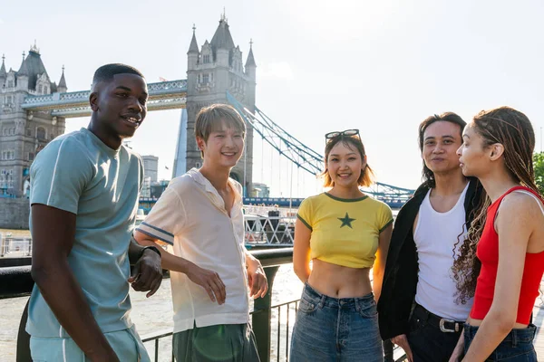 Londra 'da, Tower Bridge bölgesinde buluşup eğlenen çok ırklı genç arkadaş grubu gençlik yaşam tarzı, seyahat ve turizm konseptleri