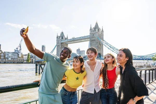 Londra 'da, Tower Bridge bölgesinde buluşup eğlenen çok ırklı genç arkadaş grubu gençlik yaşam tarzı, seyahat ve turizm konseptleri
