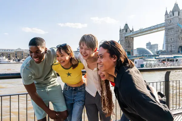 Londra 'da, Tower Bridge bölgesinde buluşup eğlenen çok ırklı genç arkadaş grubu gençlik yaşam tarzı, seyahat ve turizm konseptleri