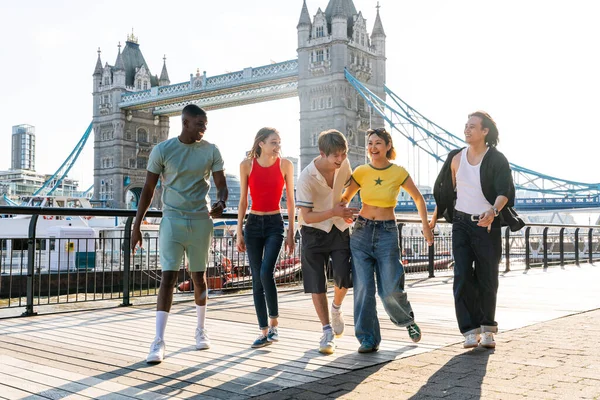 Londra 'da, Tower Bridge bölgesinde buluşup eğlenen çok ırklı genç arkadaş grubu gençlik yaşam tarzı, seyahat ve turizm konseptleri