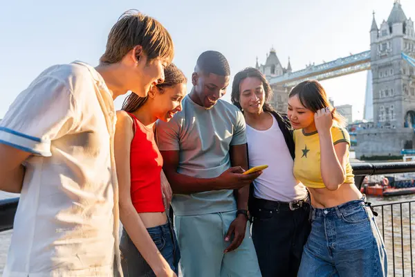Londra 'da, Tower Bridge bölgesinde buluşup eğlenen çok ırklı genç arkadaş grubu gençlik yaşam tarzı, seyahat ve turizm konseptleri