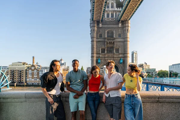 Londra 'da, Tower Bridge bölgesinde buluşup eğlenen çok ırklı genç arkadaş grubu gençlik yaşam tarzı, seyahat ve turizm konseptleri
