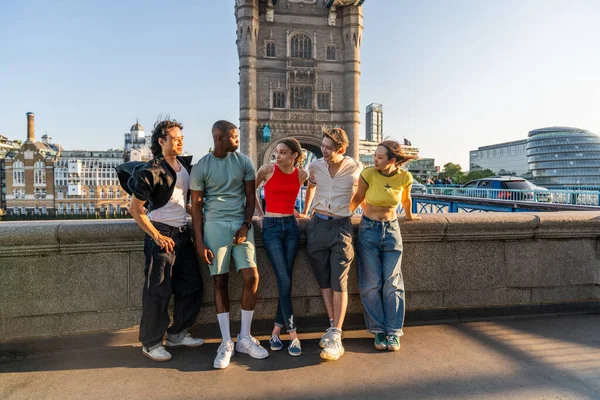 Londra 'da, Tower Bridge bölgesinde buluşup eğlenen çok ırklı genç arkadaş grubu gençlik yaşam tarzı, seyahat ve turizm konseptleri