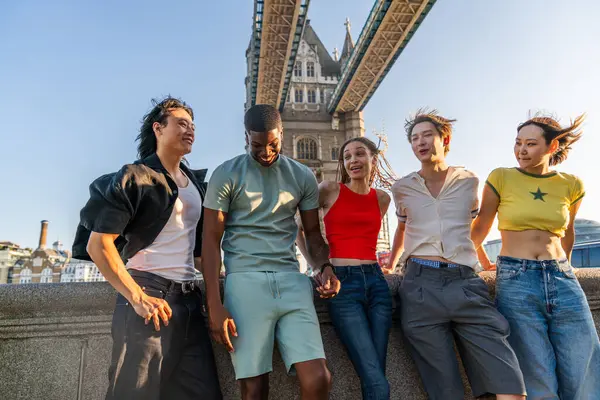 Londra 'da, Tower Bridge bölgesinde buluşup eğlenen çok ırklı genç arkadaş grubu gençlik yaşam tarzı, seyahat ve turizm konseptleri