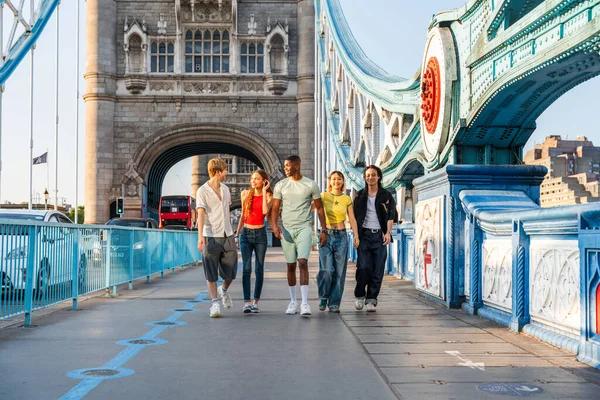 Londra 'da, Tower Bridge bölgesinde buluşup eğlenen çok ırklı genç arkadaş grubu gençlik yaşam tarzı, seyahat ve turizm konseptleri