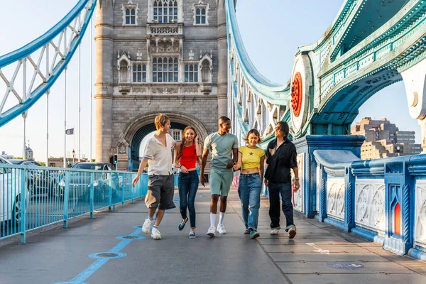 Londra 'da, Tower Bridge bölgesinde buluşup eğlenen çok ırklı genç arkadaş grubu gençlik yaşam tarzı, seyahat ve turizm konseptleri