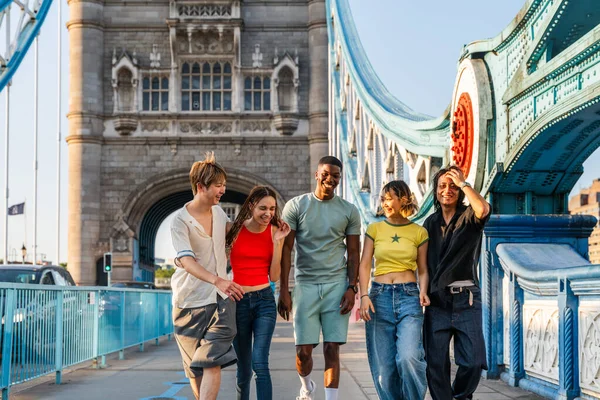Londra 'da, Tower Bridge bölgesinde buluşup eğlenen çok ırklı genç arkadaş grubu gençlik yaşam tarzı, seyahat ve turizm konseptleri