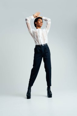 Akışkan cinsiyet Latin Latin asıllı adam stüdyoda şık kıyafetler, LGBTQ konseptleri, cinsiyetsiz ve çeşitlilikle poz veriyor.