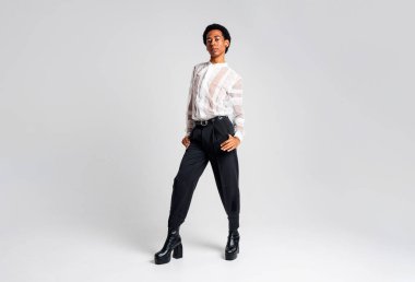 Akışkan cinsiyet Latin Latin asıllı adam stüdyoda şık kıyafetler, LGBTQ konseptleri, cinsiyetsiz ve çeşitlilikle poz veriyor.