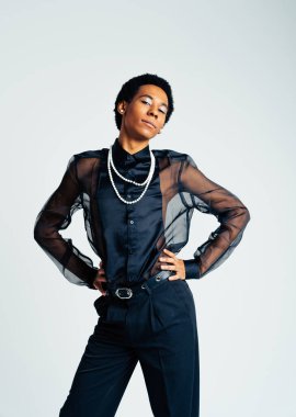 Akışkan cinsiyet Latin Latin asıllı adam stüdyoda şık kıyafetler, LGBTQ konseptleri, cinsiyetsiz ve çeşitlilikle poz veriyor.