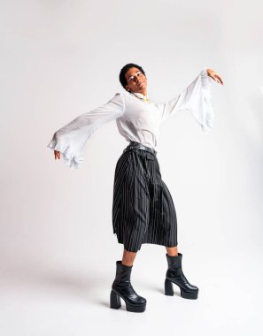 Akışkan cinsiyet Latin Latin asıllı adam stüdyoda şık kıyafetler, LGBTQ konseptleri, cinsiyetsiz ve çeşitlilikle poz veriyor.