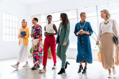 Ofiste buluşan kendine güvenen güzel iş kadınlarından oluşan bir grup çok yönlü kadın yaratıcı ekip iş yerinde beyin fırtınası yapıyorlar.