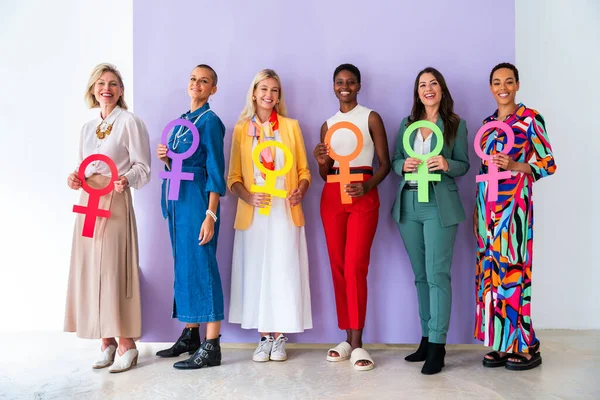 Group of beautiful confident women holding the femininity Venus symbol to celebrate women's day, concepts of women empowerment, women's right and diversity.