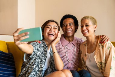 Evde kaynaşan arkadaş grubu, LGBTQ ve çeşitlilik kavramları - homoseksüel çift ve akışkan cinsiyet ayrımcılığı yapmayan, çapraz giyimli genç adam dairede eğleniyor, LGBT insanları kavramları