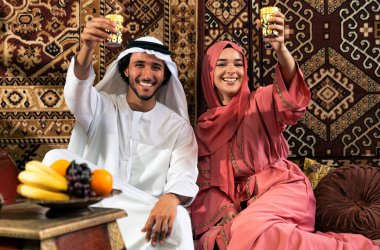 Emirati 'li genç bir çift geleneksel Arap kafesinde vakit geçiriyor. Kandura giyen kadın ve erkek Dubai 'den abaya sohbet ediyorlar..