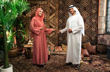 Emirati 'li genç bir çift geleneksel Arap kafesinde vakit geçiriyor. Kandura giyen kadın ve erkek Dubai 'den abaya sohbet ediyorlar..