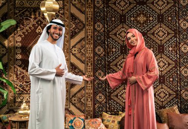 Emirati 'li genç bir çift geleneksel Arap kafesinde vakit geçiriyor. Kandura giyen kadın ve erkek Dubai 'den abaya sohbet ediyorlar..