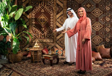 Emirati 'li genç bir çift geleneksel Arap kafesinde vakit geçiriyor. Kandura giyen kadın ve erkek Dubai 'den abaya sohbet ediyorlar..