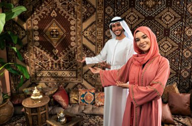 Emirati 'li genç bir çift geleneksel Arap kafesinde vakit geçiriyor. Kandura giyen kadın ve erkek Dubai 'den abaya sohbet ediyorlar..