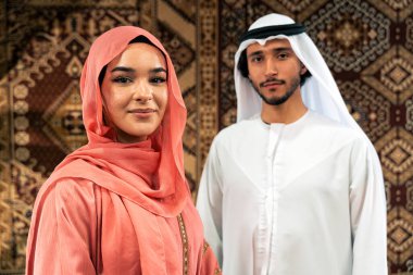 Emirati 'li genç bir çift geleneksel Arap kafesinde vakit geçiriyor. Kandura giyen kadın ve erkek Dubai 'den abaya sohbet ediyorlar..
