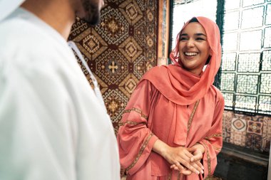 Emirati 'li genç bir çift geleneksel Arap kafesinde vakit geçiriyor. Kandura giyen kadın ve erkek Dubai 'den abaya sohbet ediyorlar..