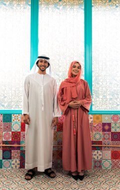 Emirati 'li genç bir çift geleneksel Arap kafesinde vakit geçiriyor. Kandura giyen kadın ve erkek Dubai 'den abaya sohbet ediyorlar..