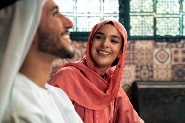 Emirati 'li genç bir çift geleneksel Arap kafesinde vakit geçiriyor. Kandura giyen kadın ve erkek Dubai 'den abaya sohbet ediyorlar..