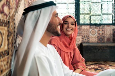 Emirati 'li genç bir çift geleneksel Arap kafesinde vakit geçiriyor. Kandura giyen kadın ve erkek Dubai 'den abaya sohbet ediyorlar..