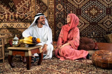 Emirati 'li genç bir çift geleneksel Arap kafesinde vakit geçiriyor. Kandura giyen kadın ve erkek Dubai 'den abaya sohbet ediyorlar..