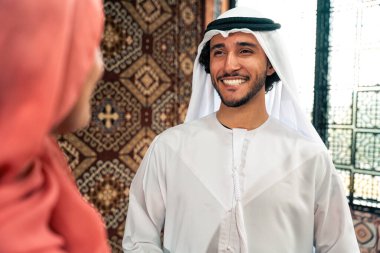 Emirati 'li genç bir çift geleneksel Arap kafesinde vakit geçiriyor. Kandura giyen kadın ve erkek Dubai 'den abaya sohbet ediyorlar..