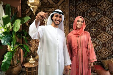 Emirati 'li genç bir çift geleneksel Arap kafesinde vakit geçiriyor. Kandura giyen kadın ve erkek Dubai 'den abaya sohbet ediyorlar..