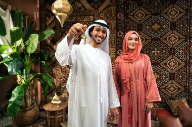 Emirati 'li genç bir çift geleneksel Arap kafesinde vakit geçiriyor. Kandura giyen kadın ve erkek Dubai 'den abaya sohbet ediyorlar..