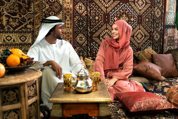 Emirati 'li genç bir çift geleneksel Arap kafesinde vakit geçiriyor. Kandura giyen kadın ve erkek Dubai 'den abaya sohbet ediyorlar..