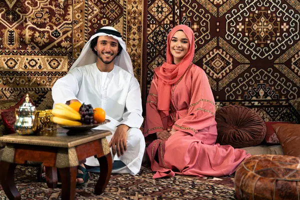 Emirati 'li genç bir çift geleneksel Arap kafesinde vakit geçiriyor. Kandura giyen kadın ve erkek Dubai 'den abaya sohbet ediyorlar..