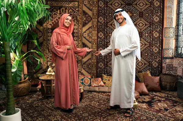 Emirati 'li genç bir çift geleneksel Arap kafesinde vakit geçiriyor. Kandura giyen kadın ve erkek Dubai 'den abaya sohbet ediyorlar..