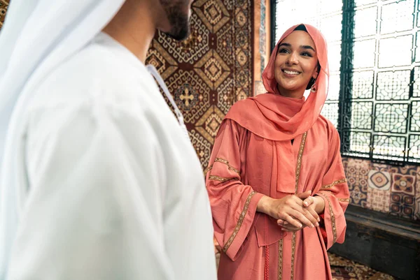 Emirati 'li genç bir çift geleneksel Arap kafesinde vakit geçiriyor. Kandura giyen kadın ve erkek Dubai 'den abaya sohbet ediyorlar..