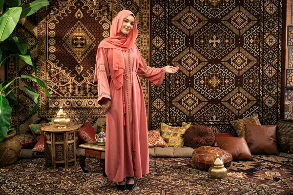 stock image Beautiful young woman wearing colored abaya indoor in an arabian traditional cafe