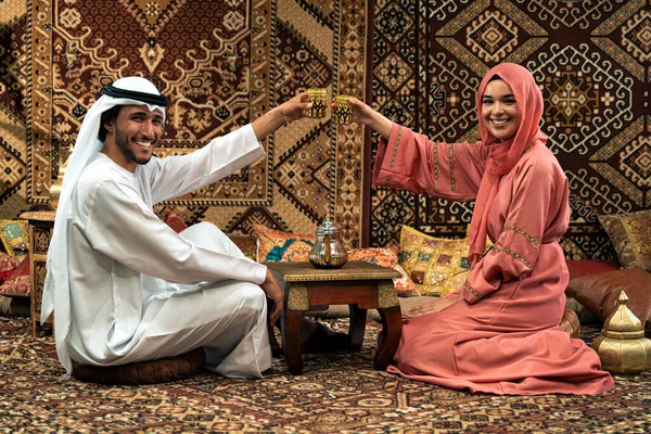 Emirati 'li genç bir çift geleneksel Arap kafesinde vakit geçiriyor. Kandura giyen kadın ve erkek Dubai 'den abaya sohbet ediyorlar..