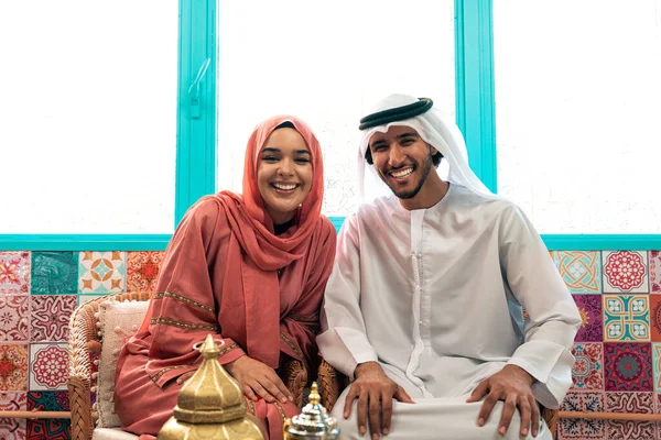 Emirati 'li genç bir çift geleneksel Arap kafesinde vakit geçiriyor. Kandura giyen kadın ve erkek Dubai 'den abaya sohbet ediyorlar..