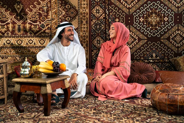 Emirati 'li genç bir çift geleneksel Arap kafesinde vakit geçiriyor. Kandura giyen kadın ve erkek Dubai 'den abaya sohbet ediyorlar..