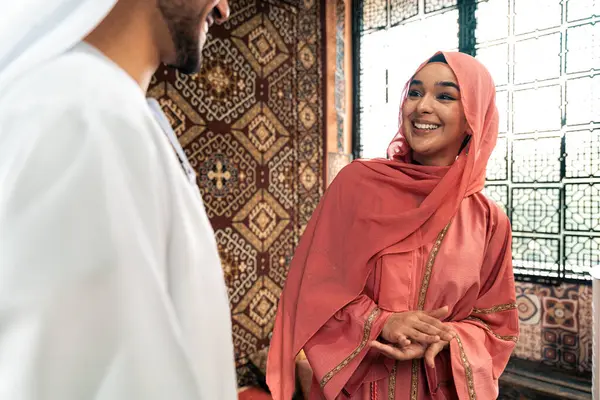 Emirati 'li genç bir çift geleneksel Arap kafesinde vakit geçiriyor. Kandura giyen kadın ve erkek Dubai 'den abaya sohbet ediyorlar..