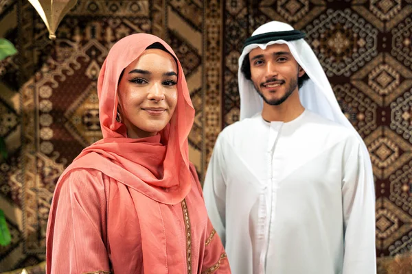 Emirati 'li genç bir çift geleneksel Arap kafesinde vakit geçiriyor. Kandura giyen kadın ve erkek Dubai 'den abaya sohbet ediyorlar..