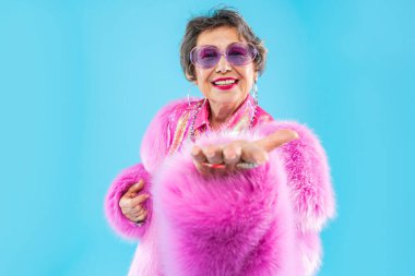 Mutlu ve komik yaşlı kadın rengarenk arka planda aşınabilir giysiler giyiyor modern havalı büyükanne portresi, yaşlı ve yaşlı insanlar hakkında kavramlar