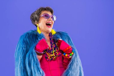 Mutlu ve komik yaşlı kadın rengarenk arka planda aşınabilir giysiler giyiyor modern havalı büyükanne portresi, yaşlı ve yaşlı insanlar hakkında kavramlar