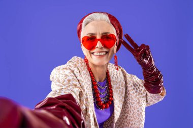 Mutlu ve komik yaşlı kadın rengarenk arka planda aşınabilir giysiler giyiyor modern havalı büyükanne portresi, yaşlı ve yaşlı insanlar hakkında kavramlar