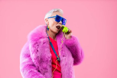 Mutlu ve komik yaşlı kadın rengarenk arka planda aşınabilir giysiler giyiyor modern havalı büyükanne portresi, yaşlı ve yaşlı insanlar hakkında kavramlar